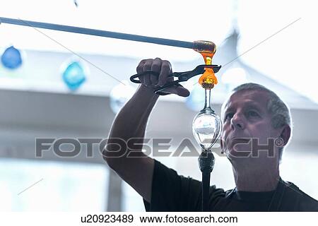 Glassblower forming molten glass View Large Photo Image Stock Photo - Glassblower forming molten glass. Fotosearch