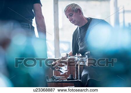 Glassblower forming molten glass View Large Photo Image Stock Photo - Glassblower forming molten glass. Fotosearch