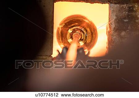 Glassblower heating glass in furnace View Large Photo Image Stock Image - Glassblower heating glass in furnace. Fotosearch