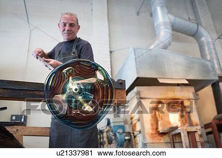 Glassblower spinning hot glass View Large Photo Image Stock Image - Glassblower spinning hot glass. Fotosearch