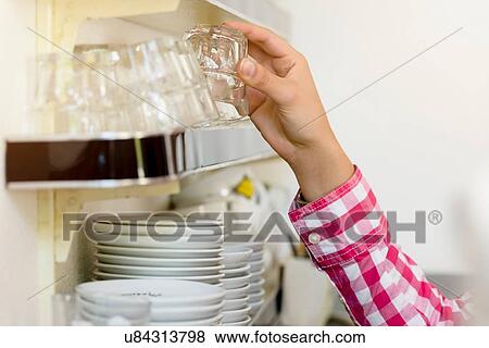 Hand of waitress in cafe picking up drinking glass from shelf View Large Photo Image Stock Photo - Hand of waitress in cafe picking up drinking glass from shelf. Fotosearch