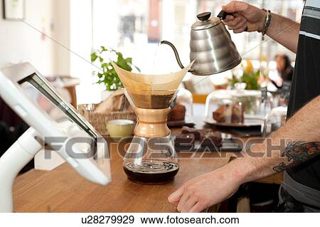 Hands of cafe waiter pouring boiling water into filter coffee pot View Large Photo Image Stock Photo - Hands of cafe waiter pouring boiling water into filter coffee pot. Fotosearch
