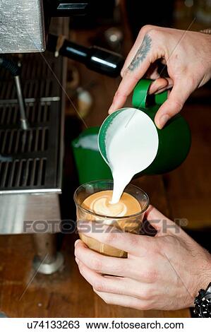 Hands of cafe waiter pouring milk foam into latte glass View Large Photo Image Stock Image - Hands of cafe waiter pouring milk foam into latte glass. Fotosearch