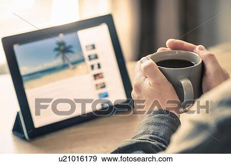 Hands of man drinking coffee with digital tablet on desk View Large Photo Image Stock Photo - Hands of man drinking coffee with digital tablet on desk. Fotosearch