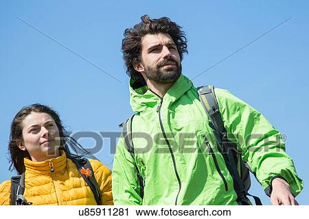 Hiking couple against blue sky View Large Photo Image Stock Image - Hiking couple against blue sky. Fotosearch