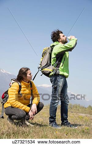 Hiking couple drinking water bottle, Vogogna, Verbania, Piemonte, Italy View Large Photo Image Picture - Hiking couple drinking water bottle, Vogogna, Verbania, Piemonte, Italy. Fotosearch