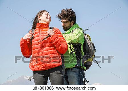 Hiking couple fastening backpacks in front of snow capped mountain, Vogogna, Verbania, Piemonte, Italy View Large Photo Image Stock Photograph - Hiking couple fastening backpacks in front of snow capped mountain, Vogogna, Verbania, Piemonte, Italy. Fotosearch