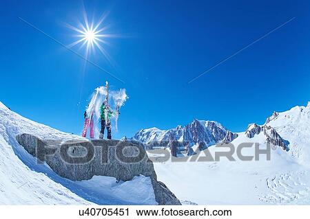 Male and female skiers shaking snow from skis on Mont Blanc massif, Graian Alps, France View Large Photo Image Stock Image - Male and female skiers shaking snow from skis on Mont Blanc massif, Graian Alps, France. Fotosearch
