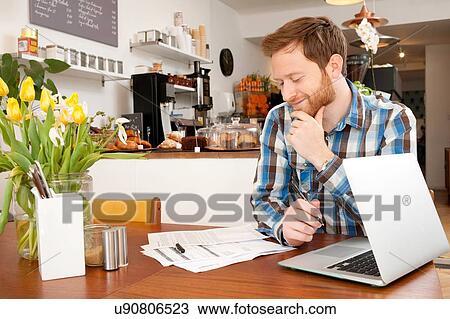 Stock Image - Male customer filling in application form in cafe. Fotosearch