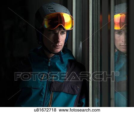 Man wearing helmet and ski goggles looking through window View Large Photo Image Stock Photo - Man wearing helmet and ski goggles looking through window. Fotosearch