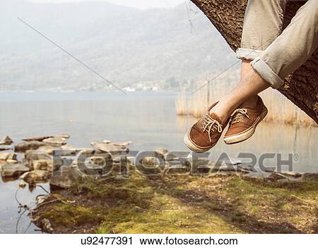 Mans feet dangling from tree on lakeside, Lake Mergozzo, Verbania, Piemonte, Italy View Large Photo Image Stock Image - Mans feet dangling from tree on lakeside, Lake Mergozzo, Verbania, Piemonte, Italy. Fotosearch