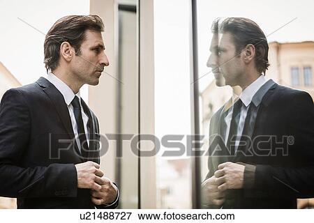 Mature businessman, looking at reflection in window View Large Photo Image Stock Photo - Mature businessman, looking at reflection in window. Fotosearch