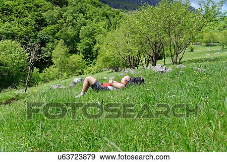 Mature male hiker lying in meadow taking a break View Large Photo Image Stock Photo - Mature male hiker lying in meadow taking a break. Fotosearch