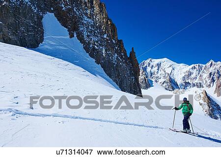 Stock Photo - Mature male skier moving up Mont Blanc massif, Graian Alps, France. Fotosearch