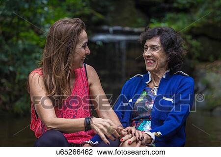 Mature woman and mother holding hands and laughing at woodland waterfall View Large Photo Image Stock Image - Mature woman and mother holding hands and laughing at woodland waterfall. Fotosearch