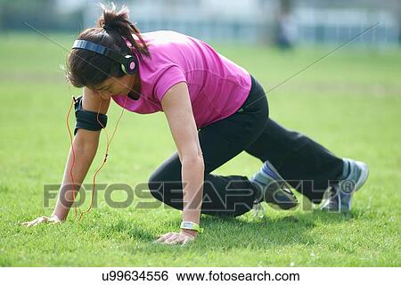 Stock Photograph - Mature woman doing exercises in park. Fotosearch