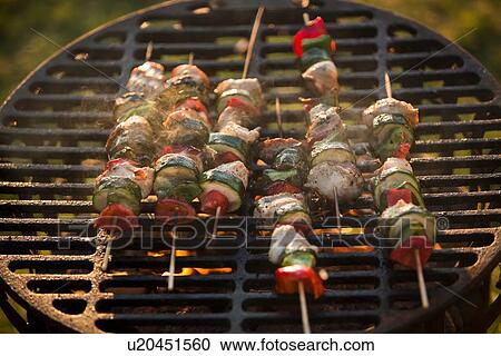 Stock Image - Meat and vegetable kebabs on barbecue. Fotosearch