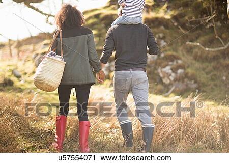 Stock Image - Mid adult couple on walk holding hands. Fotosearch