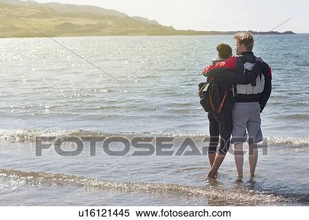 Mid adult couple with arms around each other on beach, Loch Eishort, Isle of Skye, Hebrides, Scotland View Large Photo Image Stock Photography - Mid adult couple with arms around each other on beach, Loch Eishort, Isle of Skye, Hebrides, Scotland. Fotosearch