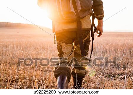 Mid adult man walking through fields, rear view, low section View Large Photo Image Stock Image - Mid adult man walking through fields, rear view, low section. Fotosearch