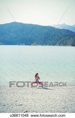 Mid adult woman, beside lake, in yoga position View Large Photo Image Stock Photo - Mid adult woman, beside lake, in yoga position. Fotosearch