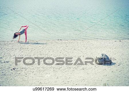 Mid adult woman, beside lake, in yoga position View Large Photo Image Stock Photo - Mid adult woman, beside lake, in yoga position. Fotosearch