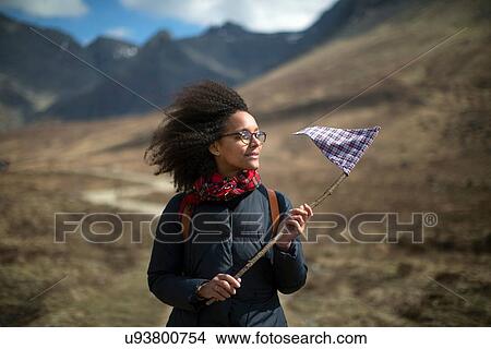 Mid adult woman holding flag, looking away View Large Photo Image Picture - Mid adult woman holding flag, looking away. Fotosearch