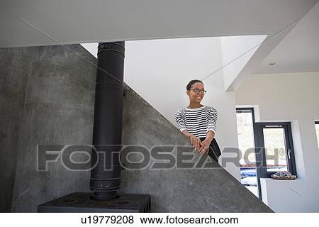 Mid adult woman in modern home interior View Large Photo Image Stock Photo - Mid adult woman in modern home interior. Fotosearch