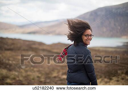 Stock Image - Mid adult woman in mountains looking at camera. Fotosearch