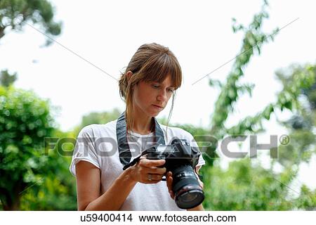 Mid adult woman looking at digital camera View Large Photo Image Picture - Mid adult woman looking at digital camera. Fotosearch