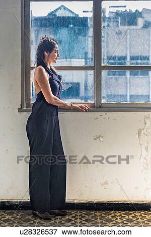 Mid adult woman looking out of window View Large Photo Image Stock Photo - Mid adult woman looking out of window. Fotosearch