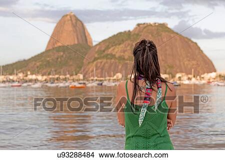 Picture - Mid adult woman looking out towards Sugarloaf mountain, Botafogo bay, Rio de Janeiro, Brazil. Fotosearch