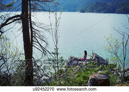 Mid adult woman, sitting on rock, in yoga position, rear view View Large Photo Image Stock Image - Mid adult woman, sitting on rock, in yoga position, rear view. Fotosearch