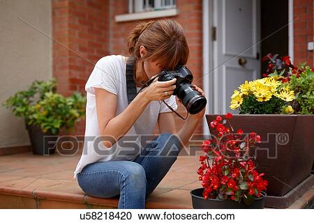 Mid adult woman sitting outdoors photographing flower pot View Large Photo Image Stock Image - Mid adult woman sitting outdoors photographing flower pot. Fotosearch