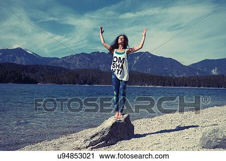 Mid adult woman, standing on rock, in yoga position View Large Photo Image Stock Image - Mid adult woman, standing on rock, in yoga position. Fotosearch