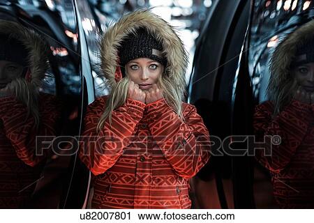 Stock Image - Mid adult woman wearing coat with furry hood, portrait. Fotosearch