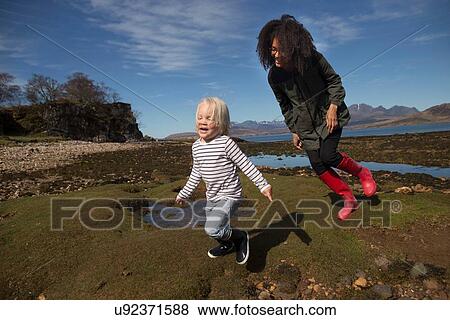 Stock Photo - Mother and son running on grass. Fotosearch