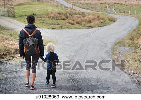 Mother and son walking on country road holding hands, rear view View Large Photo Image Stock Photo - Mother and son walking on country road holding hands, rear view. Fotosearch