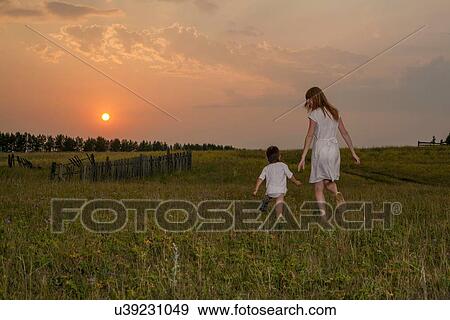 Mother and son walking through field at sunset, rear view, Sarsy village, Sverdlovsk region, Russia View Large Photo Image Stock Photo - Mother and son walking through field at sunset, rear view, Sarsy village, Sverdlovsk region, Russia. Fotosearch