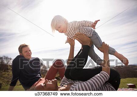 Mother balancing son on feet View Large Photo Image Stock Photo - Mother balancing son on feet. Fotosearch