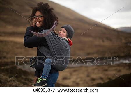 Mother carrying son in sling View Large Photo Image Stock Photo - Mother carrying son in sling. Fotosearch