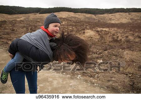 Stock Photograph - Mother carrying son in sling. Fotosearch