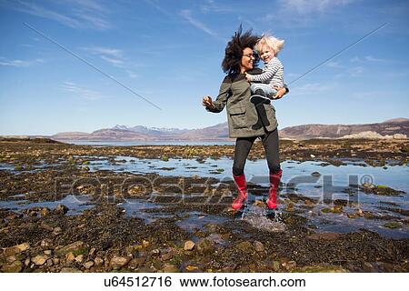 Mother holding son jumping in Loch Eishort, Isle of Skye, Hebrides, Scotland View Large Photo Image Stock Photograph - Mother holding son jumping in Loch Eishort, Isle of Skye, Hebrides, Scotland. Fotosearch
