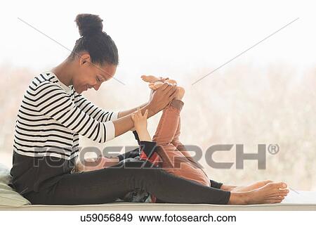 Mother playing with son, holding his feet View Large Photo Image Stock Photo - Mother playing with son, holding his feet. Fotosearch