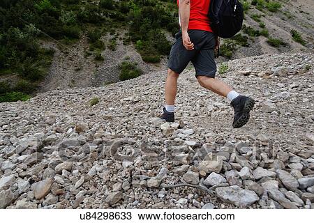 Neck down view of mature male hiker hiking in stoney valley View Large Photo Image Stock Image - Neck down view of mature male hiker hiking in stoney valley. Fotosearch