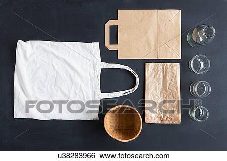 Stock Photograph - Overhead still life of reusable and paper bags and glasses. Fotosearch