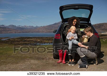 Stock Photography - Parents helping son change shoes, Loch Eishort, Isle of Skye, Hebrides, Scotland. Fotosearch