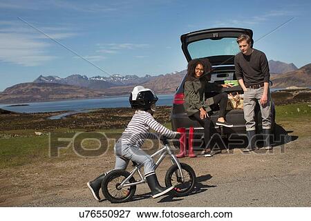 Parents watching son ride bike, Loch Eishort, Isle of Skye, Hebrides, Scotland View Large Photo Image Stock Photo - Parents watching son ride bike, Loch Eishort, Isle of Skye, Hebrides, Scotland. Fotosearch