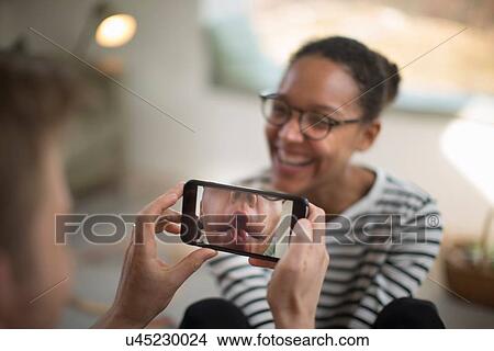 Person holding smartphone, woman laughing View Large Photo Image Picture - Person holding smartphone, woman laughing. Fotosearch
