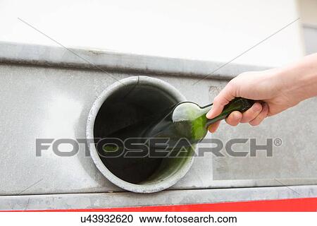 Person recycling wine bottle in bottle bank View Large Photo Image Stock Image - Person recycling wine bottle in bottle bank. Fotosearch